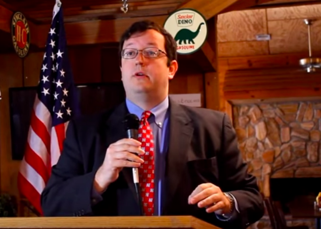 Pay no attention to the unbiblical dinosaur behind Georgia State Sen. Josh McKoon.